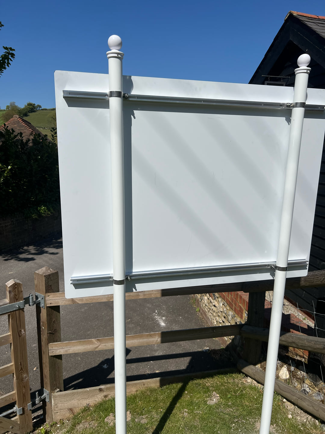 Rear construction and white posts of the installed Lydden Village Hall sign