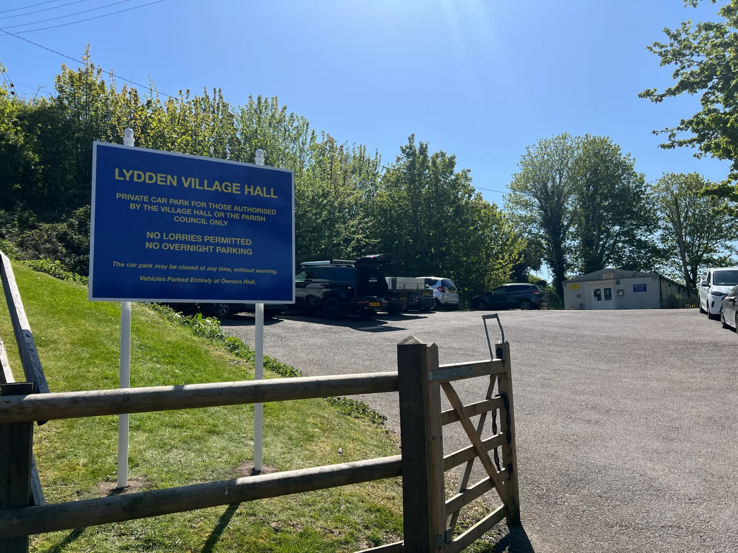 Before and after Lydden Village Hall car park sign in Kent, showing new post and panel signage by Purple Frog Signs.