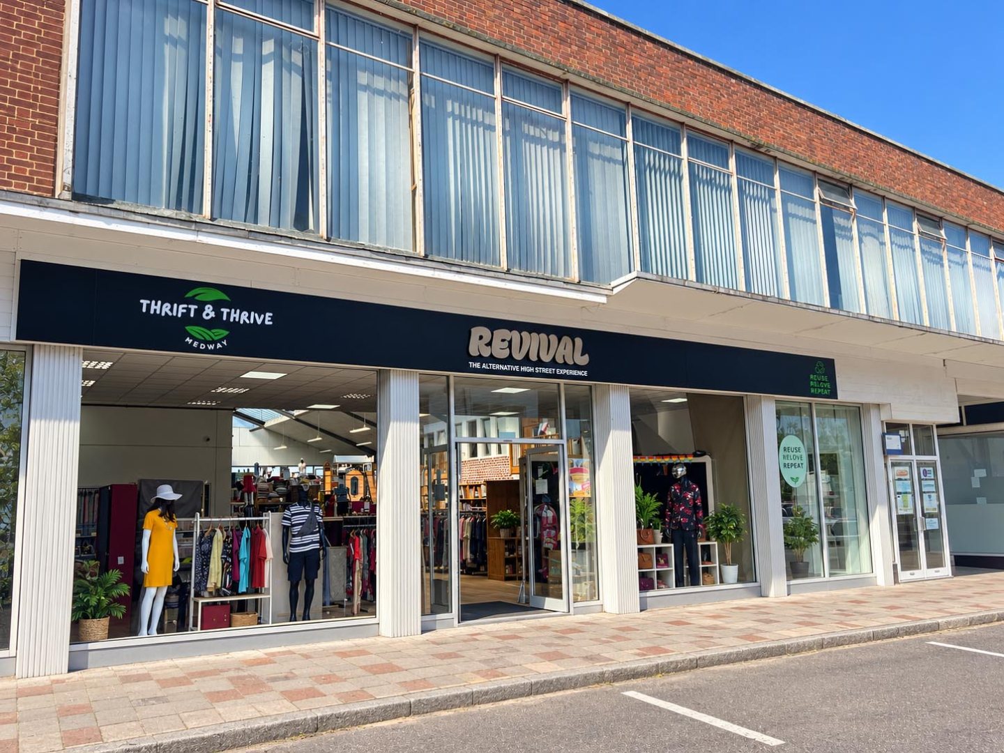 Revamped Thrift & Thrive and Revival shopfront with black fascia signage, branded lettering and clear retail window displays.
