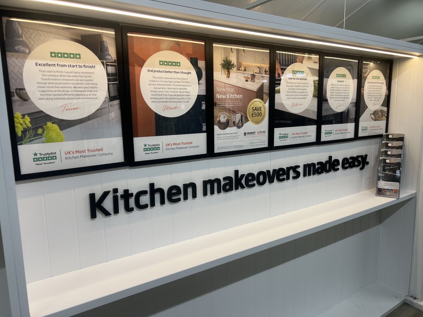 Printed display boards for granite transformation in black frames in a retail setting