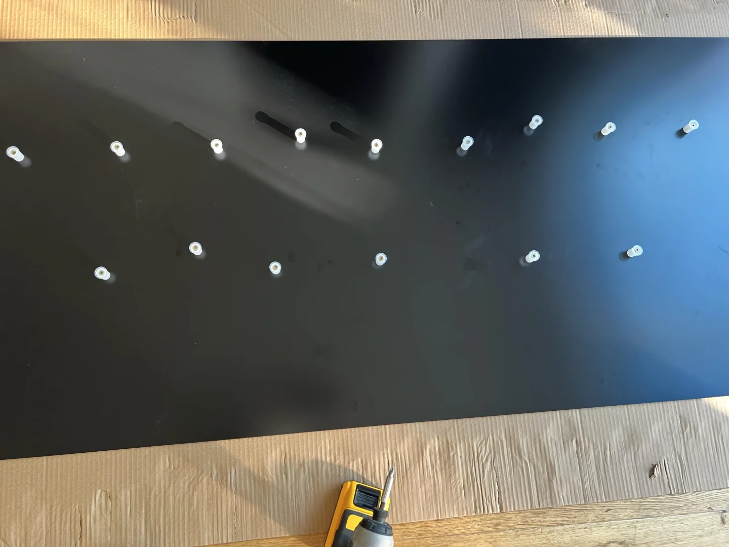 White stand-off fixings installed in two rows on a matt black ACM fascia panel, ready to support the raised REVIVAL lettering for Thrift & Thrive’s Chatham shopfront.